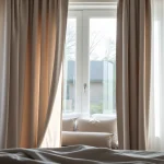 Verduisterende gordijnen die elegant zonlicht blokkeren in een serene slaapkamer.
