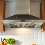 Install exhaust hood installation over a modern stovetop in a professional kitchen setting.